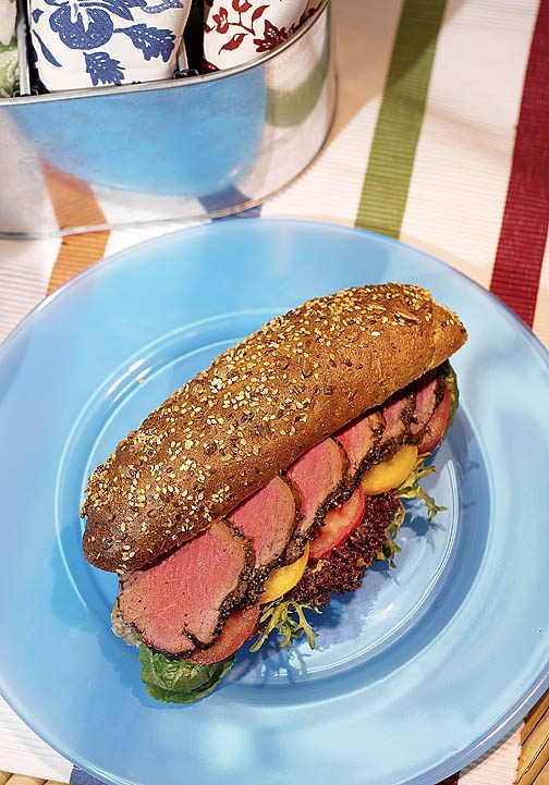 Sandwich on a blue plate over a striped tablecloth