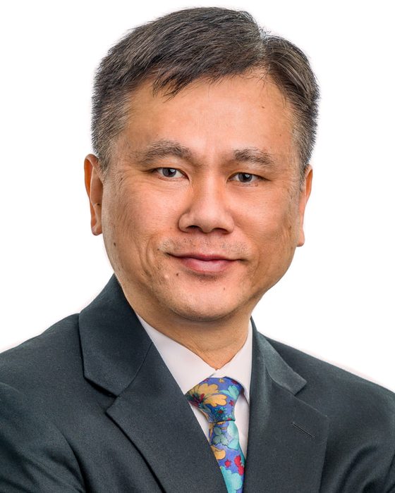 Corporate headshot of a man in a grey suit