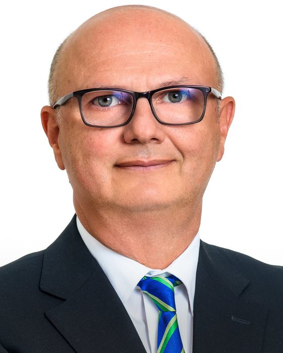 Corporate headshot of a man in glasses on white