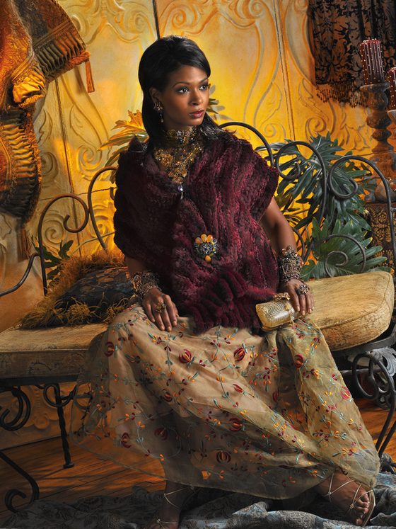 Woman in traditional dress seated in an ornate garden